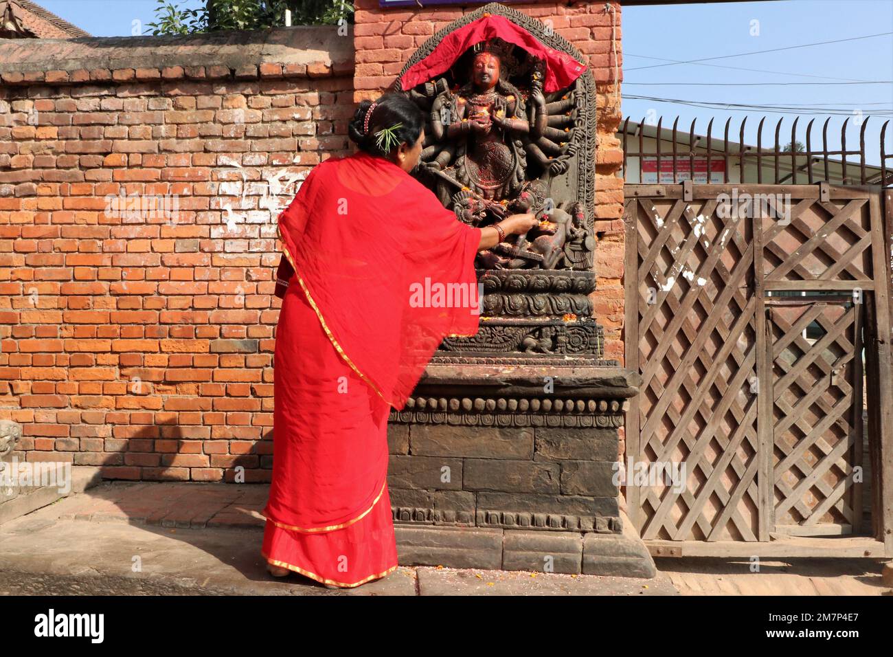 Bhaktapur, Népal, 19 octobre 2018 - Une dame portant la traditionnelle saree rouge de NNewari offre des prières à la déesse, Bhabani près de Bhaktapur, Népal Banque D'Images