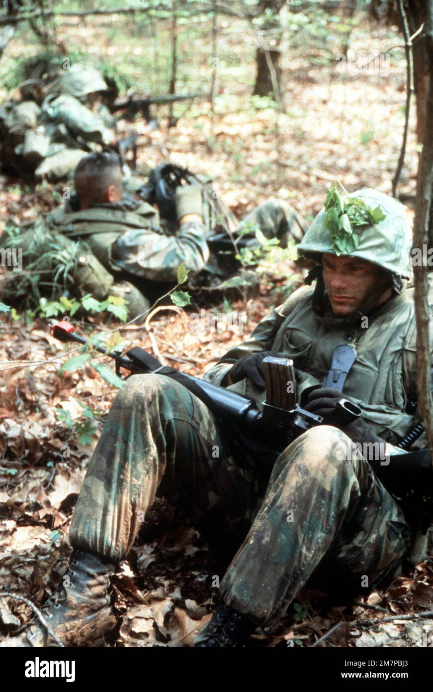 Un candidat d'officier de marine prêt au combat est l'opérateur radio de son peloton. Il attend un message pour dire au peloton de sortir après leur pause. Ces candidats sont des étudiants de l'École de base pour la formation de combat des officiers de la Marine. Base: Corps de marine base, Quantico État: Virginie (va) pays: Etats-Unis d'Amérique (USA) Banque D'Images