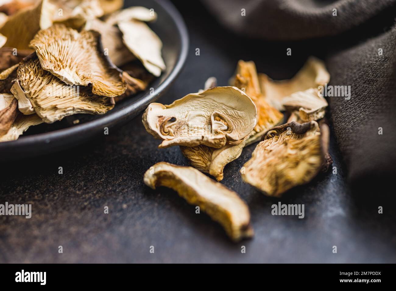 Champignons séchés tranchés sur la table noire. Banque D'Images