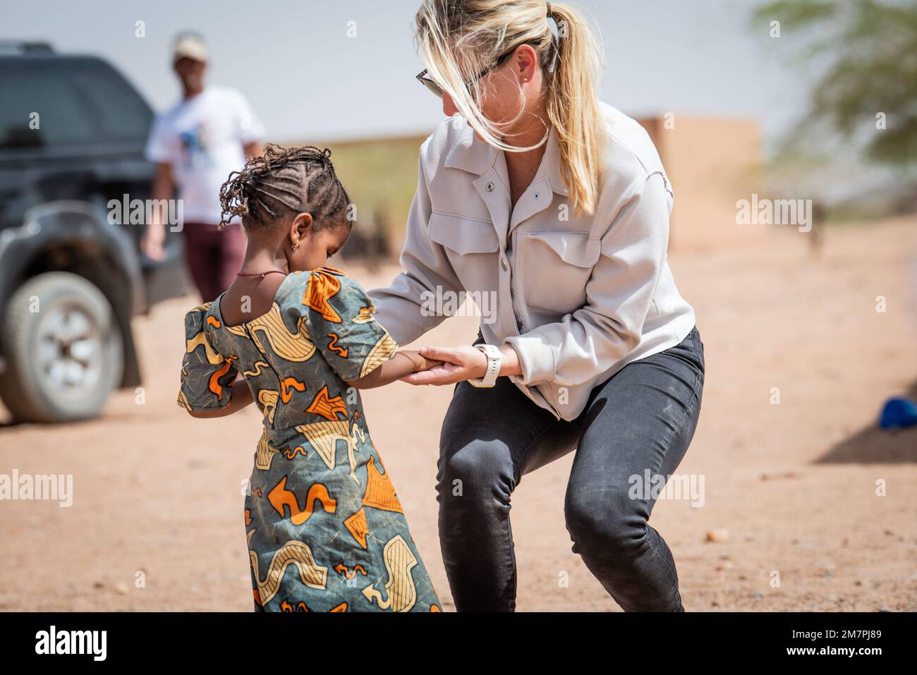 A ÉTATS-UNIS AirForce Airman affecté au groupe expéditionnaire aérien 409th (AEG), danse avec une jeune fille à l'Ecole Azel, Niger, 11 mai 2022. Les membres de l'AEG de 409th ont livré des fournitures scolaires et médicales à l'Ecole Azel, la plus grande école de la région au nord-est de la ville d'Agadez. Les relations établies au cours de ces événements offrent la possibilité d'un engagement et d'un partenariat accrus avec la communauté pour accroître la stabilité, permettre aux gouvernements locaux et améliorer la qualité de vie des citoyens du Niger. Banque D'Images