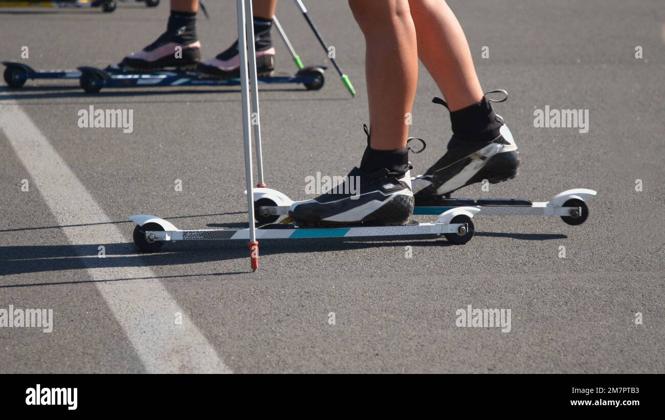 Gros plan de skis et de pieds de roller sur eux d'un coureur à la ligne de départ Banque D'Images