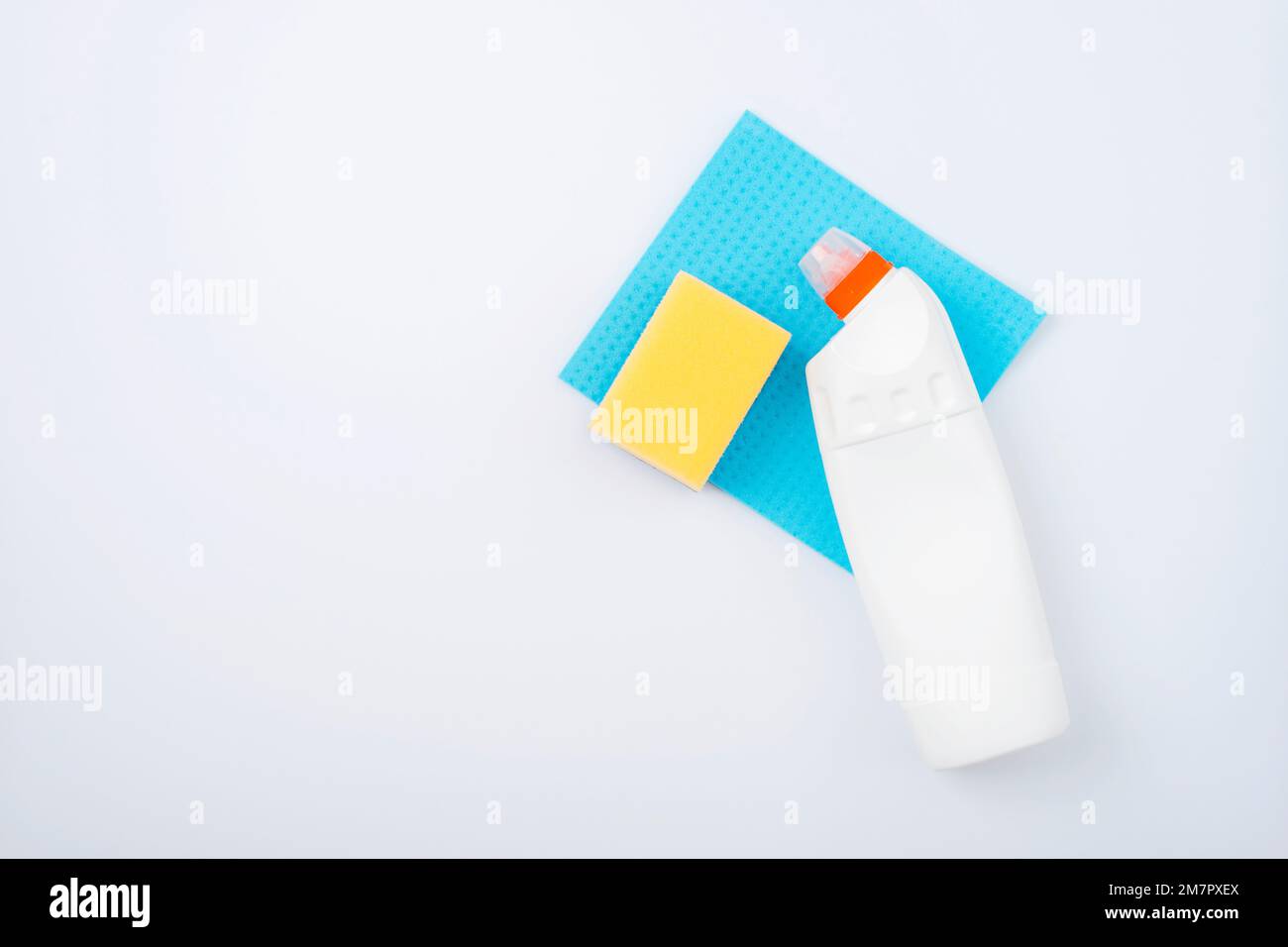 Concept de nettoyage à la maison, ménage, hygiène, corvées, fournitures de nettoyage. Produit de nettoyage, chiffon bleu et éponge jaune sur fond blanc. Vue de dessus, fl Banque D'Images