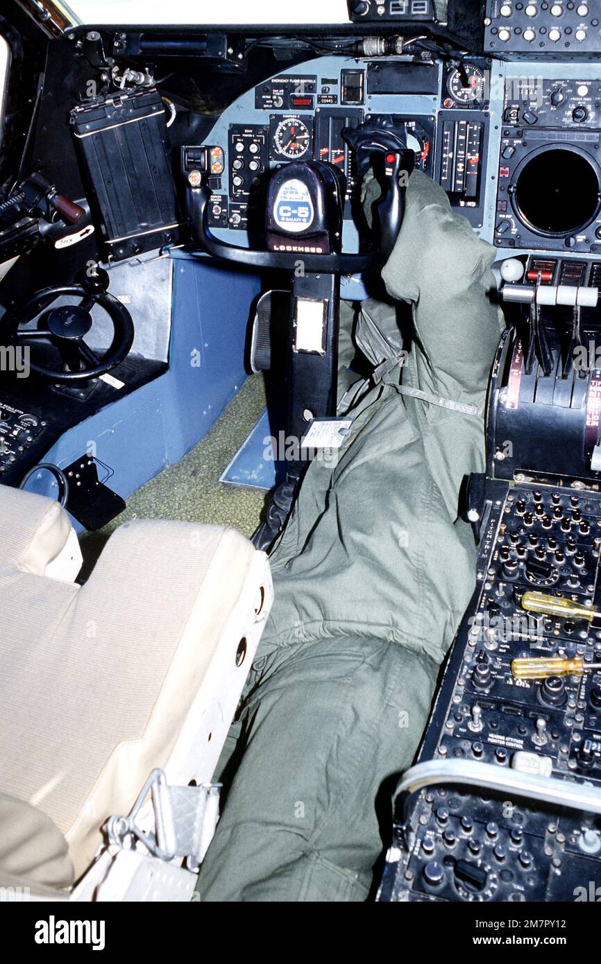 Un membre de l'équipage de l'escadron de maintenance avionique 436th, vêtu de matériel de guerre chimique, effectue l'entretien du panneau de commande dans le poste de pilotage d'un avion C-5A Galaxy au cours d'un essai d'équipement de défense de guerre chimique. Base: Dover Air Force base État: Delaware (DE) pays: Etats-Unis d'Amérique (USA) Banque D'Images