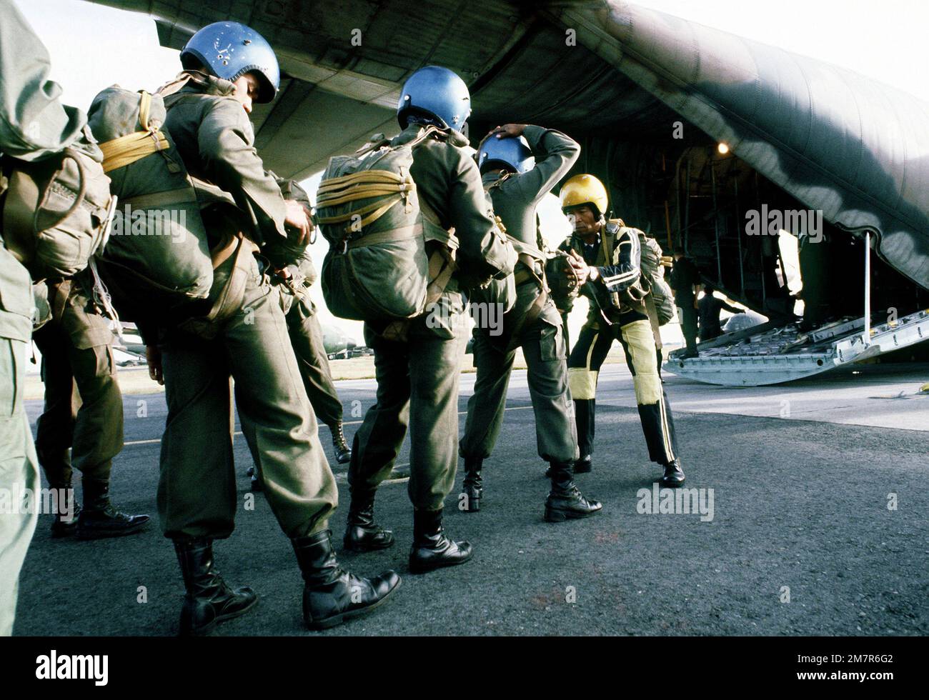Les parachutistes de l'armée philippine font vérifier leur équipement par un capitaine-jumpmaster avant d'embarquer dans l'escadre C-130 du transport aérien tactique de 374th. Base: Clark Air base État: Luzon pays: Philippines (PHL) Banque D'Images