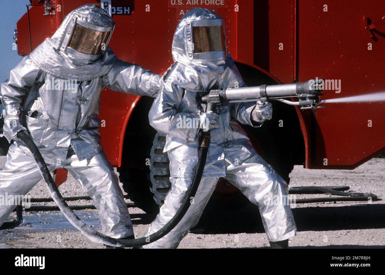 Les pompiers s'entraînent avec l'équipement de pulvérisation. PARTICIPATION au concours PHOTO AAV, couleur, 1981 mars, « Air Force Fire Fighters ». Base: Vandenberg Air Force base État: Californie (CA) pays: États-Unis d'Amérique (USA) Banque D'Images