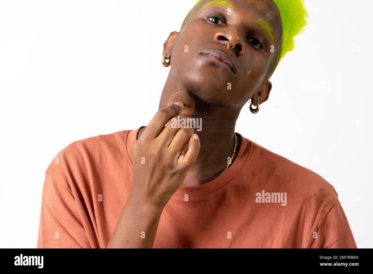 Un homme noir androgyne posant sur le maquillage, concept LGTBI, application de rousseur, fond blanc Banque D'Images