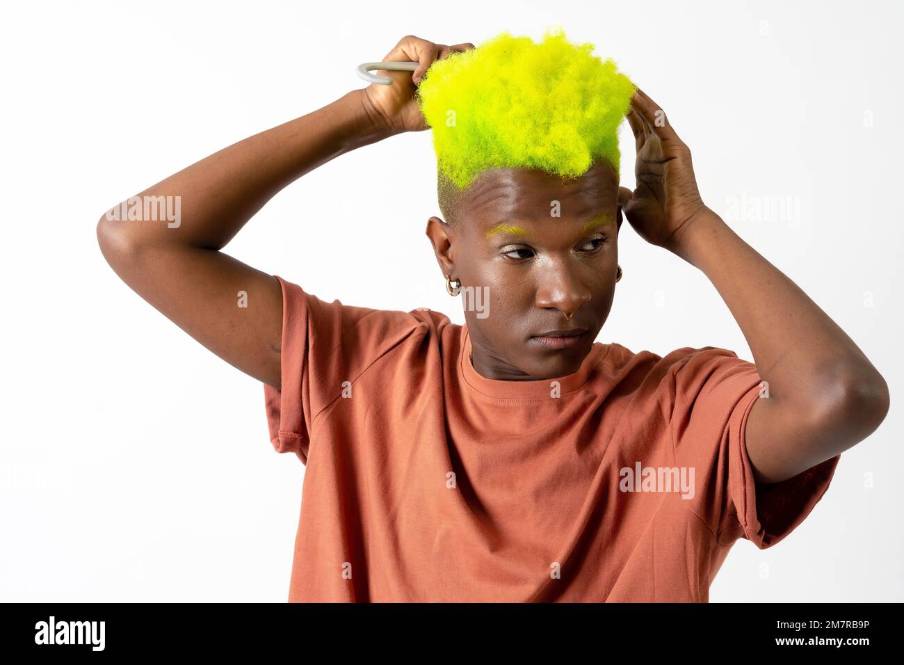Gay noir ethnique homme mettant sur le maquillage, LGTBI concept, peignant ses cheveux verts magnifiques Banque D'Images