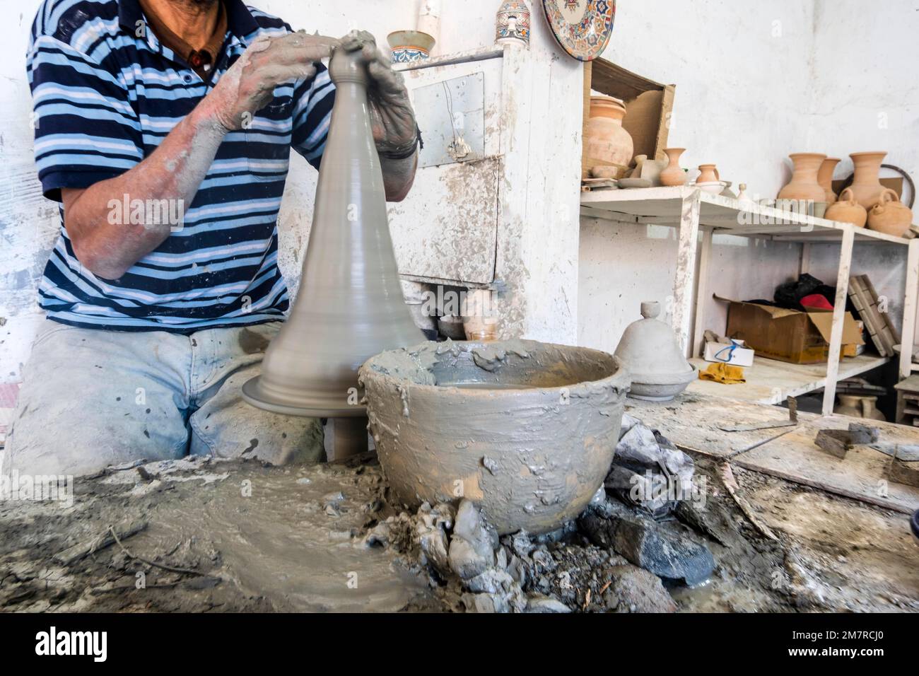 potier habile formant un navire d'argile grise dans une usine de poterie, Fès, Maroc, Afrique du Nord Banque D'Images