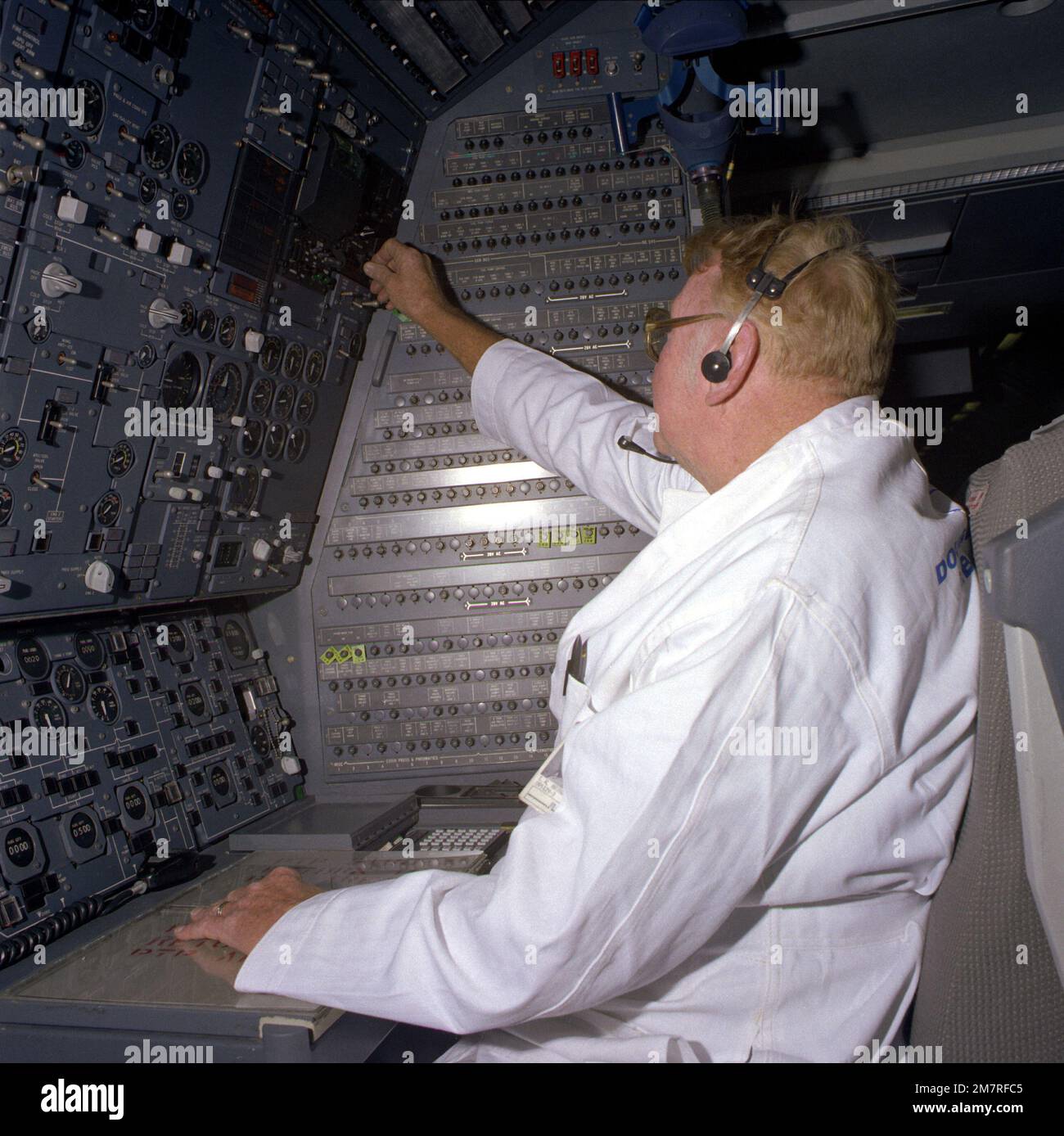 Un employé civil de McDonnell Douglas Corp. Effectue des essais à la station de l'ingénieur de bord à bord d'un avion KC-10A Extender. Pays : inconnu Banque D'Images