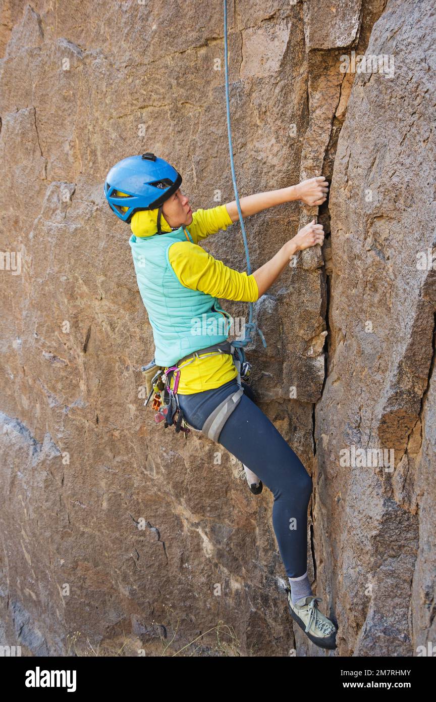 Femme asiatique escalade sur la roche dans la gorge de la rivière Owens Banque D'Images