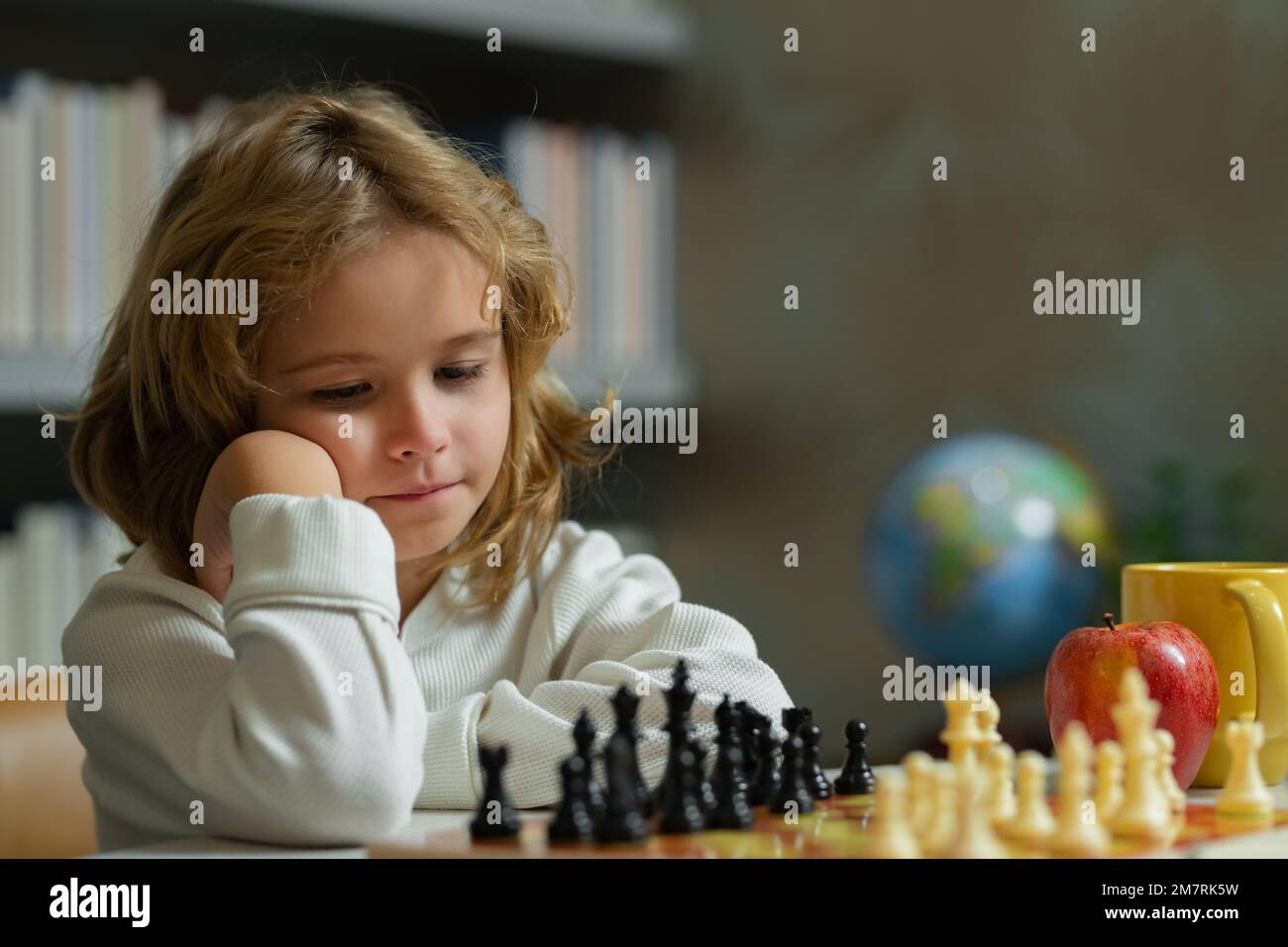 École d'échecs. Enfant pense ou plan au jeu d'échecs dans la salle de classe. Des écoliers intelligents, intelligents et intelligents. Développement et logique du cerveau. Banque D'Images