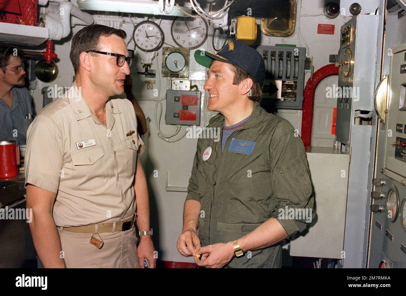 Le secrétaire de la Marine John F. Lehman Jr., à droite, et le CDR Nicholas Stasko visitent une chaufferie lors de la visite de Lehman à bord du porte-avions USS KITTY HAWK (CV-63). Base: Pearl Harbor État: Hawaï (HI) pays: Etats-Unis d'Amérique (USA) Banque D'Images