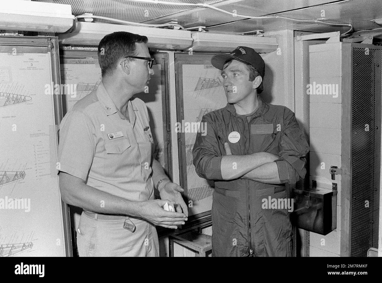 Le secrétaire de la Marine John F. Lehman Jr., à droite, s'entretient avec le CDR Nicholas Stasko lors de la visite de Lehman à bord du porte-avions USS KITTY HAWK (CV-63). Base: Pearl Harbor État: Hawaï (HI) pays: Etats-Unis d'Amérique (USA) Banque D'Images