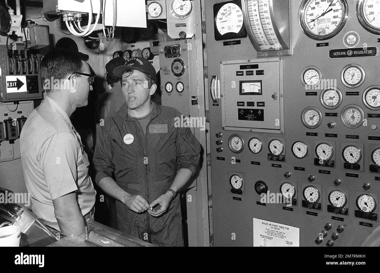 Le secrétaire de la Marine John F. Lehman Jr., à droite, et le CDR Nicholas Stasko visitent une chaufferie lors de la visite de Lehman à bord du porte-avions USS KITTY HAWK (CV-63). Base: Pearl Harbor État: Hawaï (HI) pays: Etats-Unis d'Amérique (USA) Banque D'Images