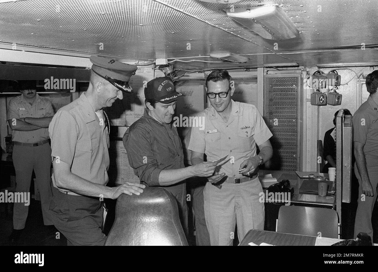 Le secrétaire de la Marine John F. Lehman Jr., au centre, et un assistant, à gauche, s'entretenir avec le CDR Nicholas Stasko lors de la visite de Lehman à bord du porte-avions USS KITTY HAWK (CV-63). Base: Pearl Harbor État: Hawaï (HI) pays: Etats-Unis d'Amérique (USA) Banque D'Images