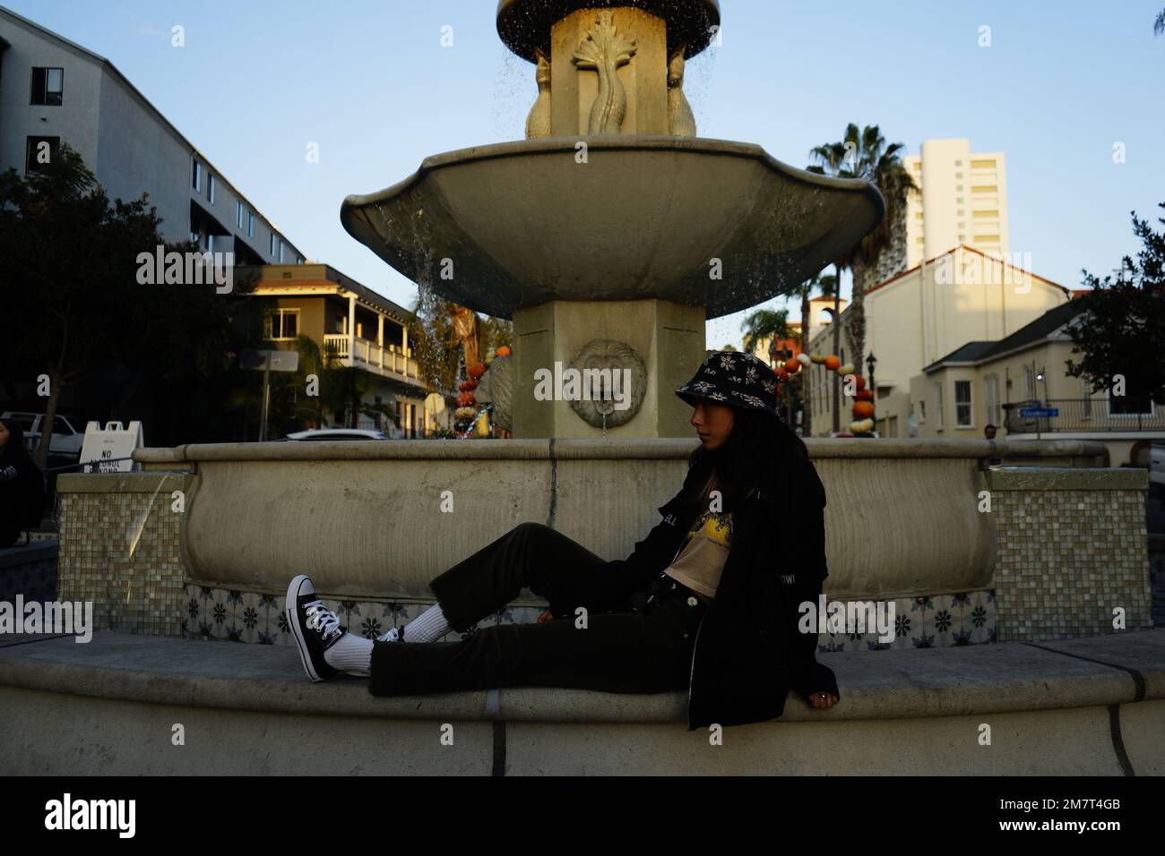 Le modèle est placé devant une fontaine. La photo est prise avec une grande ouverture, une sensibilité ISO faible et une vitesse d'obturation élevée. Banque D'Images
