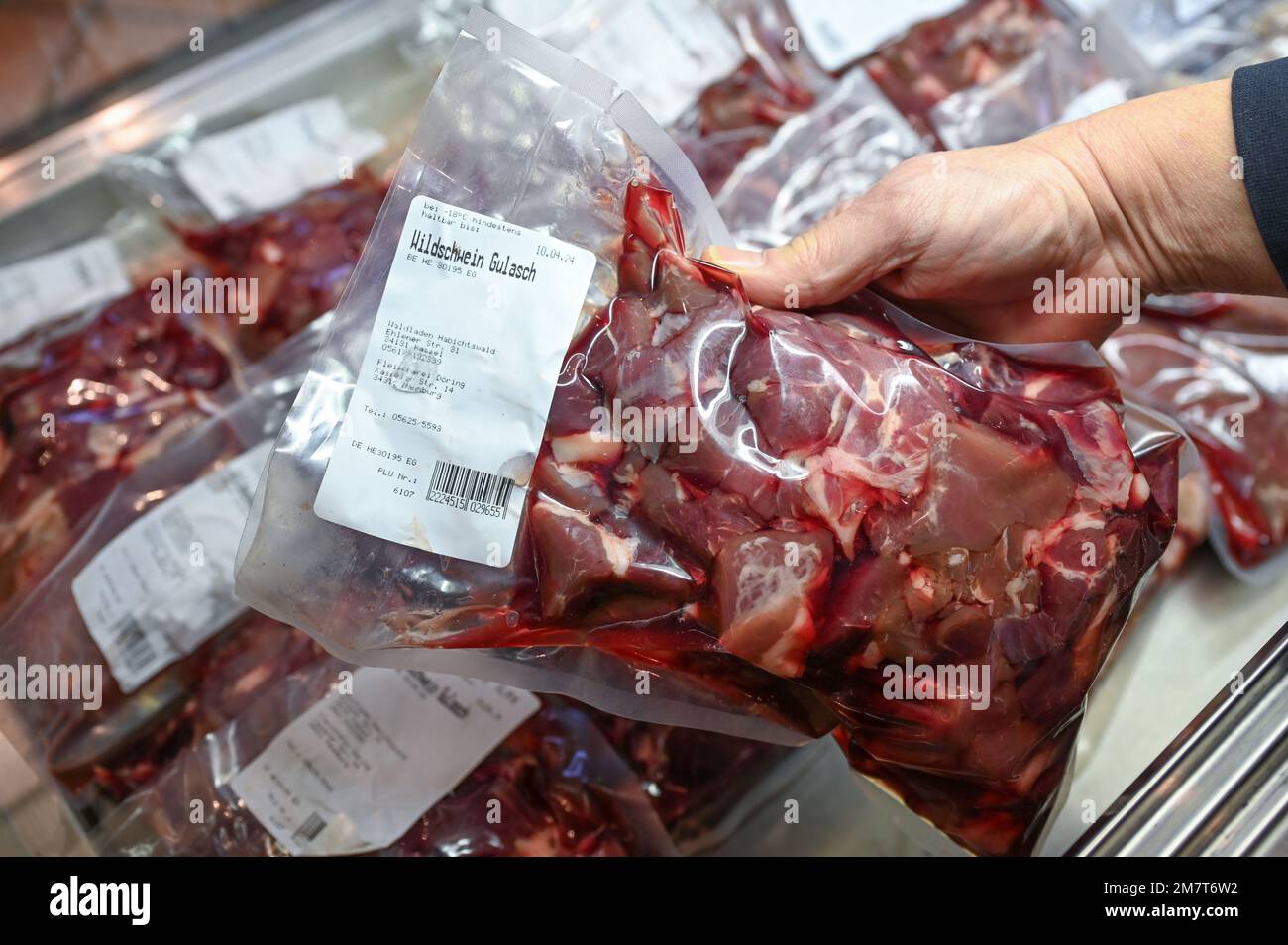 Kassel, Allemagne. 06th janvier 2023. Une main retire une portion emballée de goulash de sanglier du comptoir réfrigéré dans le magasin forestier. La viande de venaison, de cerf, de sanglier et d'autres animaux de gibier est populaire auprès des consommateurs de Hesse. (À dpa: 'Viande de gibier en demande toute l'année - 'plus biologique à peine possible') Credit: Uwe Zucchi/dpa/Alay Live News Banque D'Images