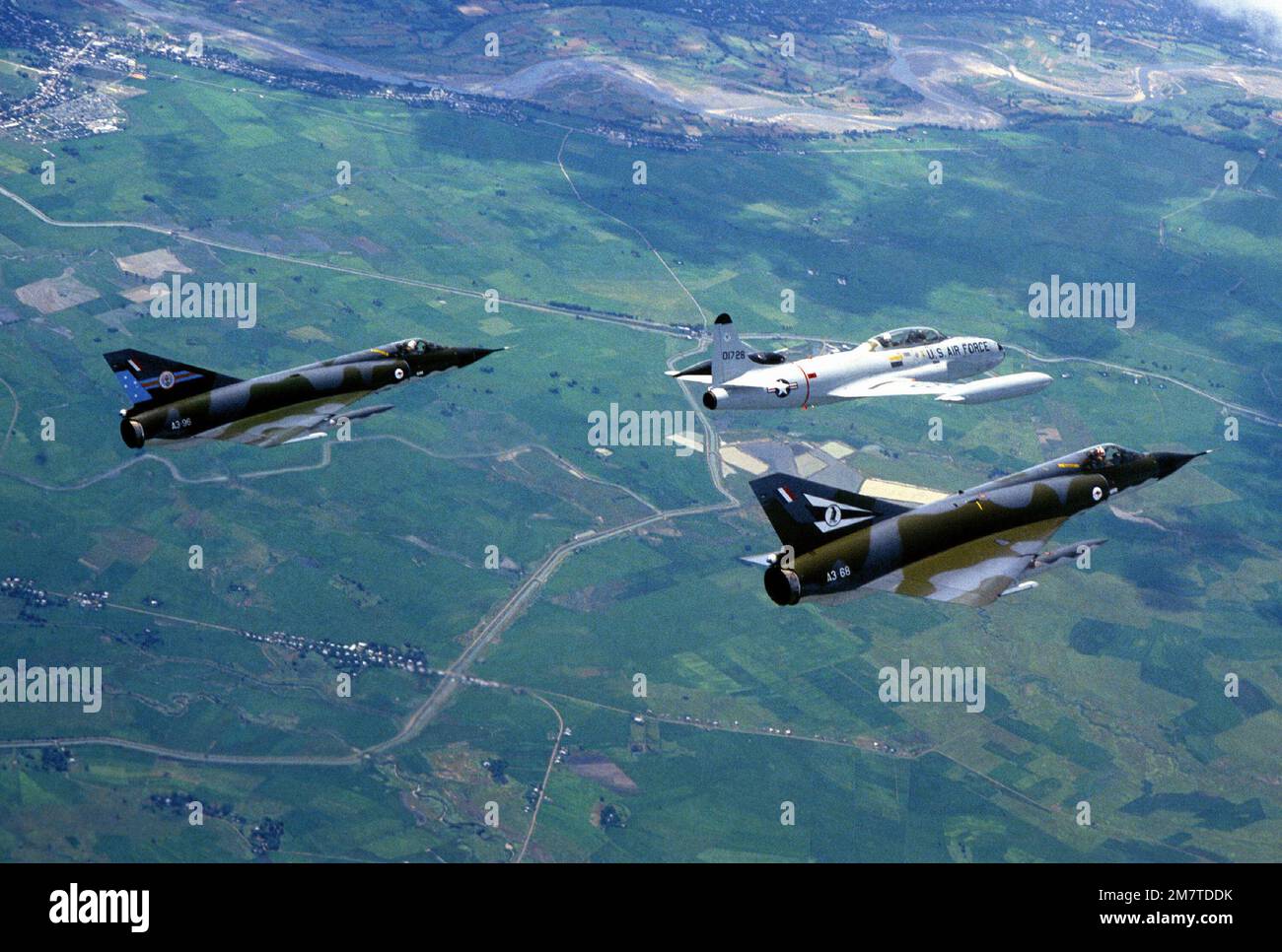 Vue aérienne à droite d'un avion T-33 Shooting Star et de deux avions Royal Australian Air Force CA-29 Mirage pendant l'exercice COPE Thunder. Objet opération/série: COPE THUNDER base: Clark Air base État: Luzon pays: Philippines (PHL) Banque D'Images