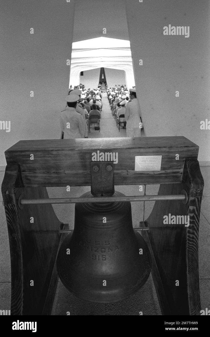 Vue sur l'une des deux cloches utilisées sur le navire de guerre USS ARIZONA (BB-39). La cloche a été placée à l'entrée de l'USS ARIZONA Memorial. En arrière-plan, une cérémonie commémorant le 40th anniversaire de l'attaque japonaise sur Pearl Harbor a lieu. Base: Pearl Harbor État: Hawaï (HI) pays: Etats-Unis d'Amérique (USA) Banque D'Images