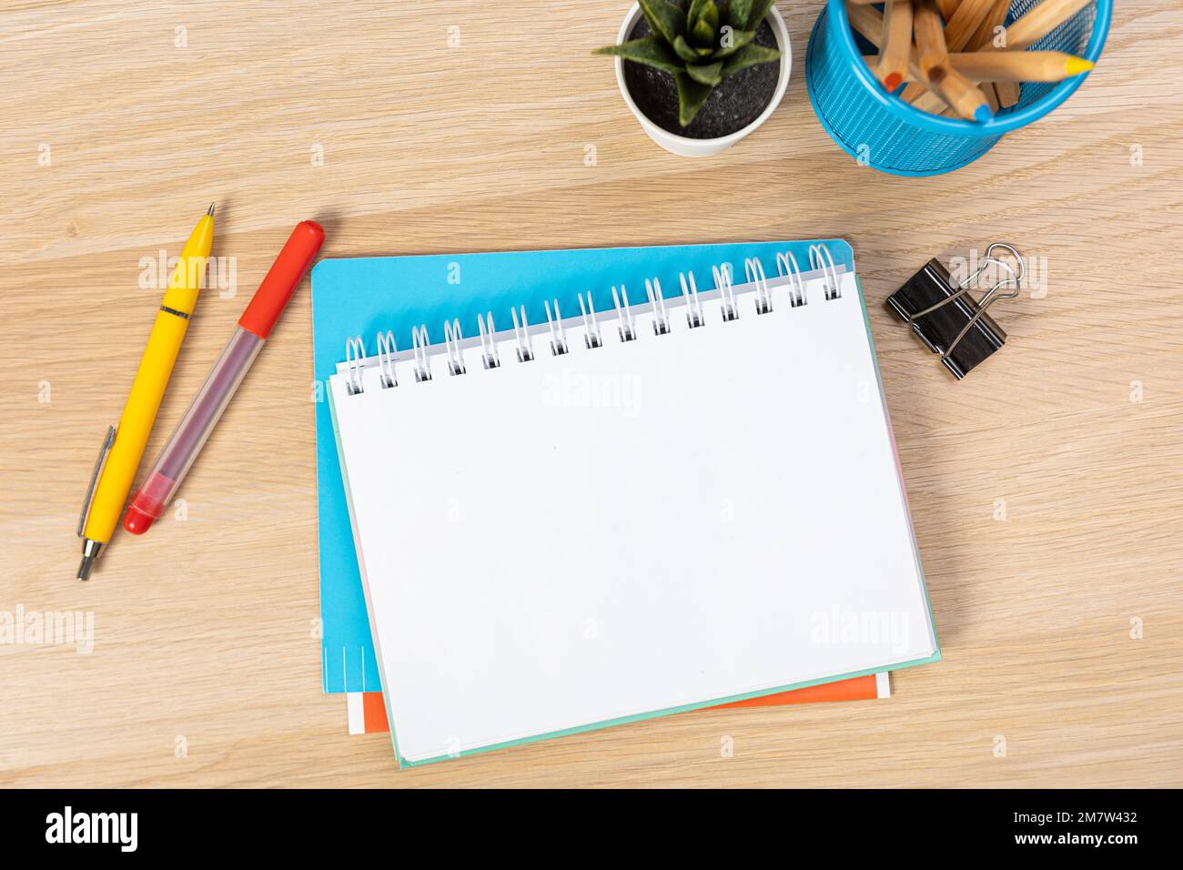 Concept de retour à l'école. Photo de dessus des blocs-notes, stylos, aiguiseurs, règle, agrafeuses, pinces, marqueurs et gommes à effacer sur une table en bois Banque D'Images