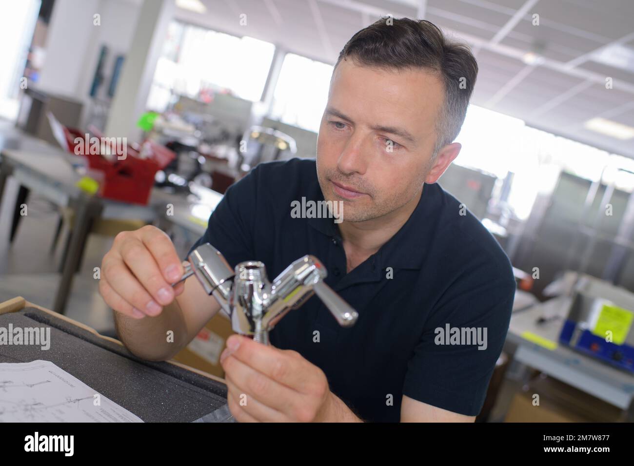 le concepteur du robinet inspecte le produit final Banque D'Images