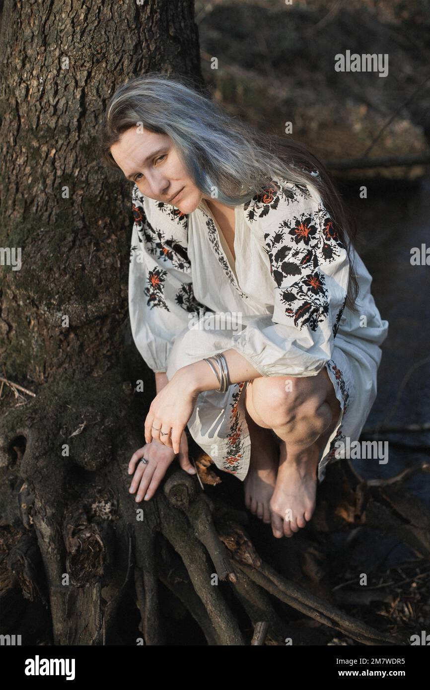 Gros plan femme adulte portant une blouse brodée regardant une photo de portrait de voie latérale Banque D'Images