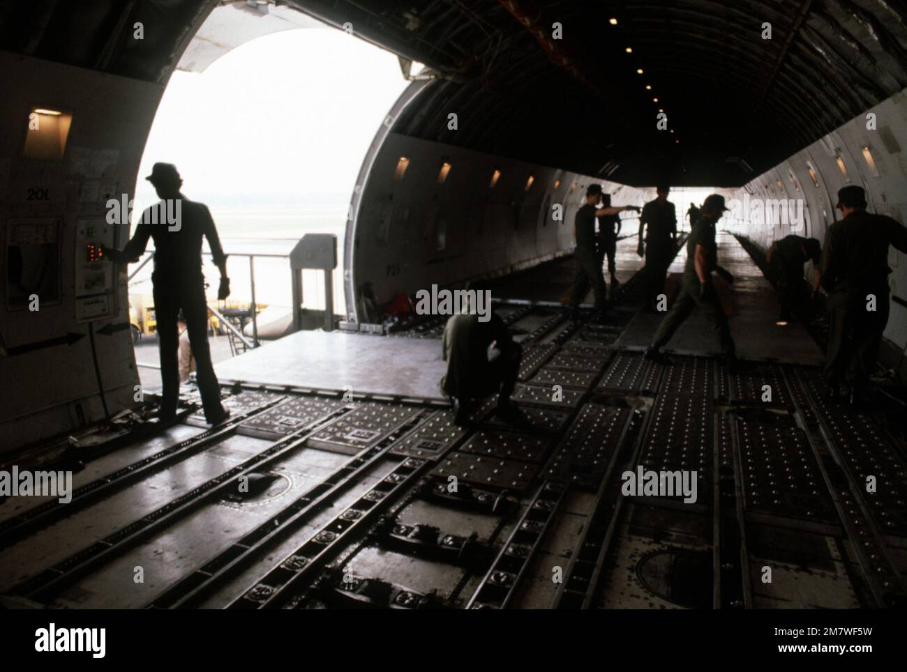 Un plancher de palettes métalliques est posé par des crèwmen en préparation au chargement de l'équipement par la porte arrière latérale d'un avion cargo 747 pendant l'opération Ocean Venture '82. Objet opération/série : OCEAN VENTURE '82 base : fort Campbell État : Kentucky (KY) pays : États-Unis d'Amérique (USA) Banque D'Images