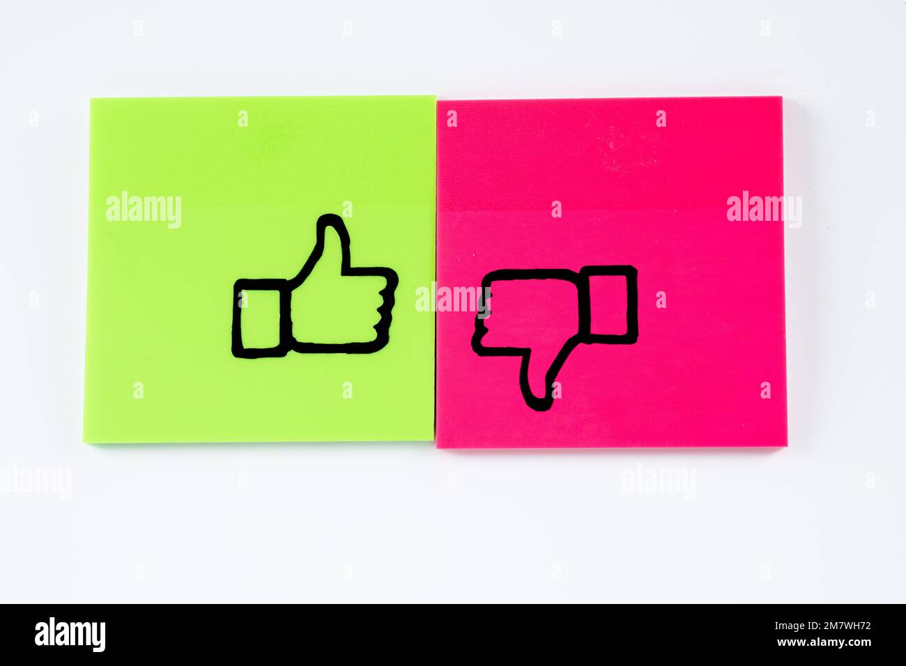 graphique dessiné à la main en stylo noir sur les notes adhésives de couleur pouces vers le haut et vers le bas oui non isolé sur un fond blanc Banque D'Images