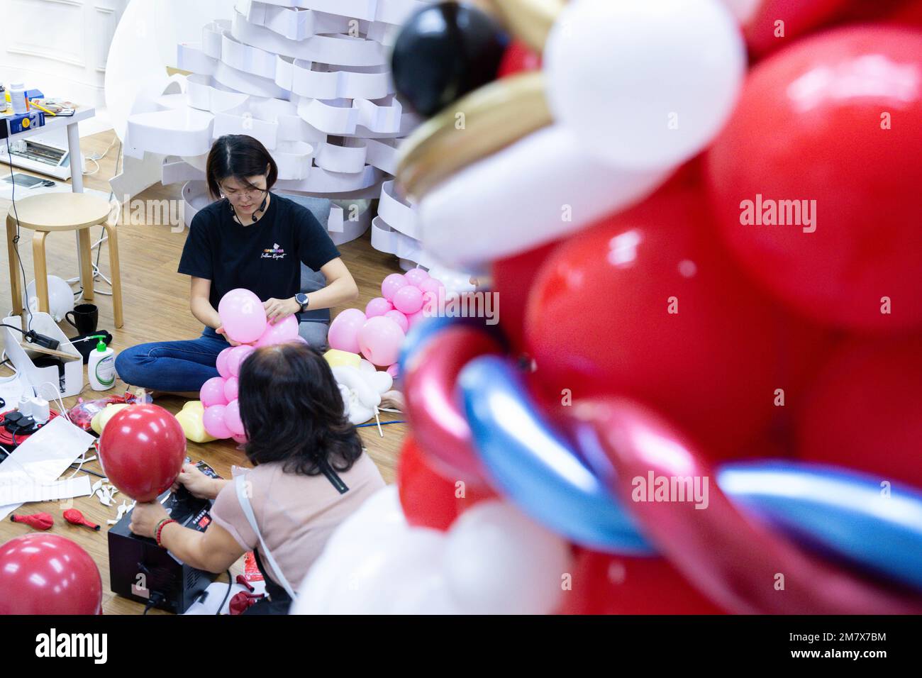 (230111) -- KUALA LUMPUR, le 11 janvier 2023 (Xinhua) -- Syndy Tan Sing Yit (Upper) et ses collègues travaillent à l'atelier de Tan près de Kuala Lumpur, en Malaisie, le 11 janvier 2023. Syndy Tan Sing Yit est un styliste malaisien de ballons qui travaille sur la modélisation de ballons depuis plus d'une décennie. Elle a créé des sculptures de ballons de danse de lion en se référant à des graphiques et des images de danse de lion. Selon Tan, faire une sculpture de ballon de danse de lion a besoin de plus de 500 ballons, pendant lesquels il est important d'ajuster la couleur des yeux et la proportion des lèvres et le menton afin de mettre en évidence le charme du lion. ( Banque D'Images