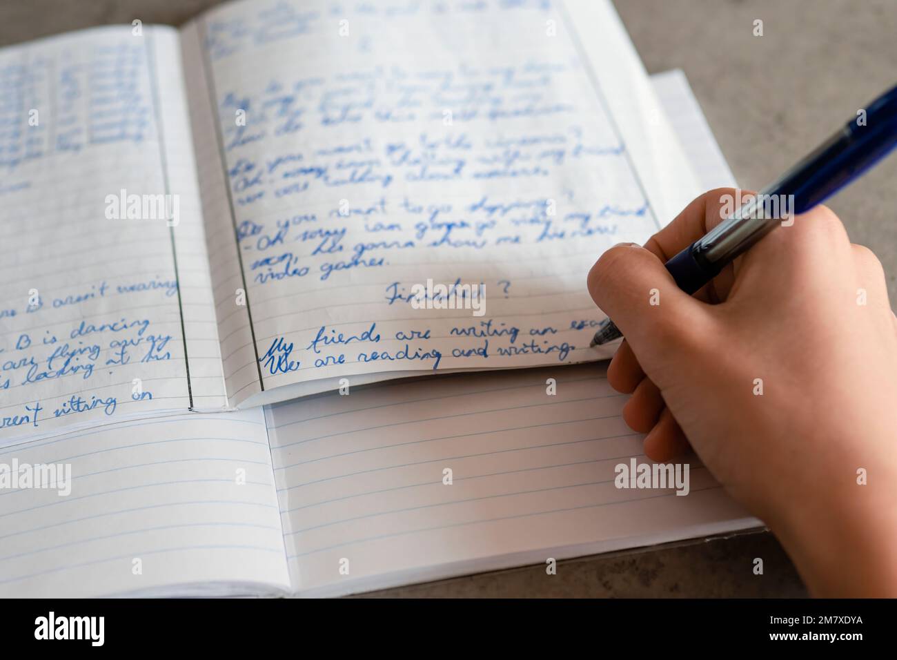 Un adolescent écrit avec un stylo dans un carnet. Enfant faisant des devoirs à l'école. L'éducation, les difficultés d'apprentissage, le mauvais concept de rédaction de main Banque D'Images