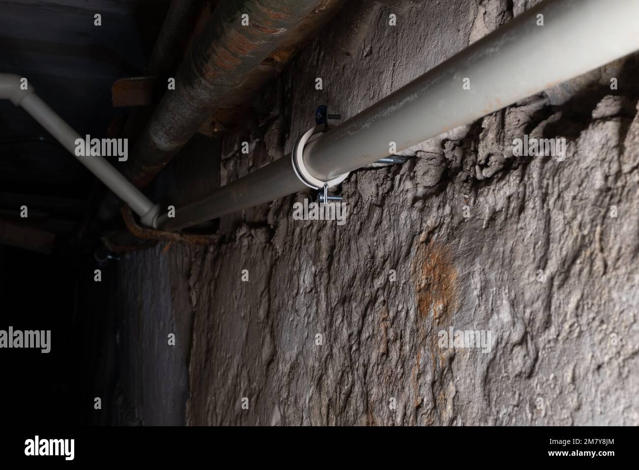 Communication de plomberie sur fond flou de ténèbres dans le sous-sol de la maison avec éclairage local Banque D'Images