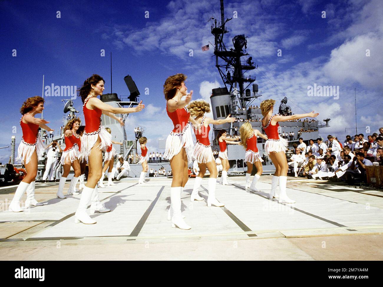 Les cheerleaders de Dallas Cowboy exécutent leur spectacle de l'USO « America and Her Music » sur le pont du croiseur de missiles guidés à propulsion nucléaire USS BAINBRIDGE (CGN-25). Les membres d'équipage du destroyer de missile guidé USS WADDELL (DDG-24) regardent de leur navire. Pays: Océan Indien (CIO) Banque D'Images