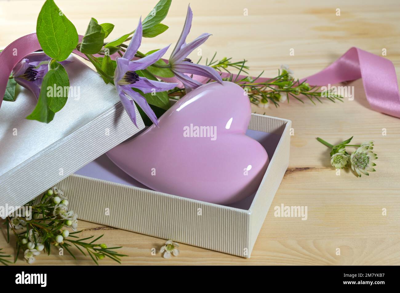 Violet lavande forme entendue du verre dans une boîte cadeau ouverte et quelques fleurs d'une table en bois, symbole d'amour et arrangement de carte de voeux pour Valentines Banque D'Images