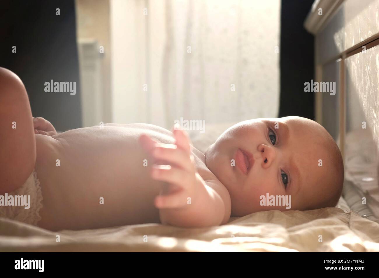 Bébé nouveau-né mignon couché sur le dos et joue avec des jouets colorés. Un  petit enfant de trois mois prend un jouet. Jeu de nouveau-né. Concept de  l'enfance Photo Stock - Alamy