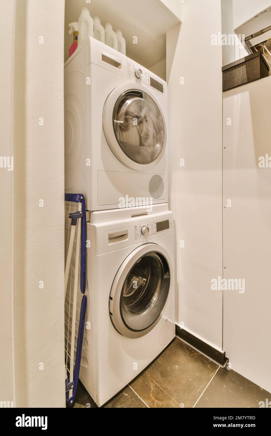 une buanderie avec lave-linge et sèche-linge à l'étage devant la porte de la machine à laver Banque D'Images