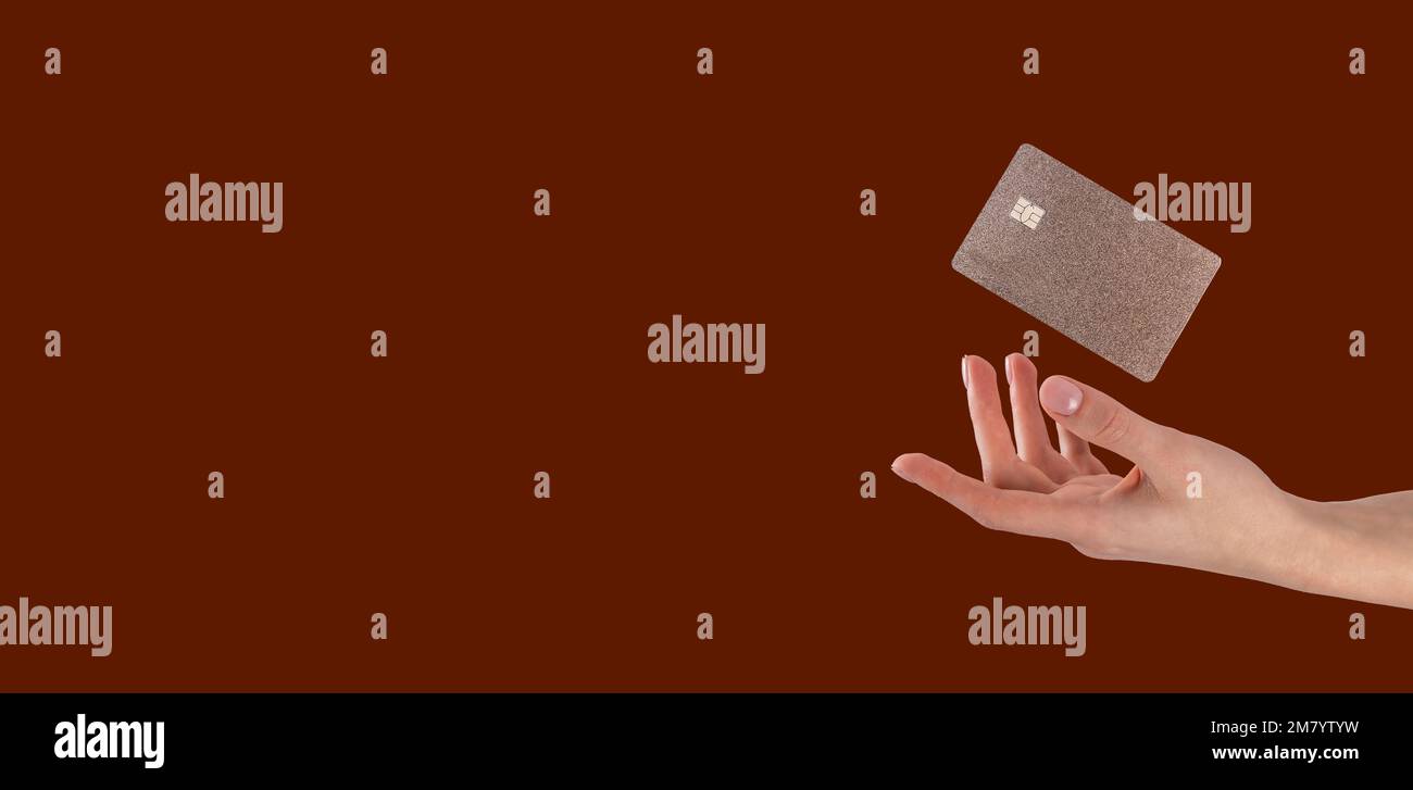 Main avec lévitant bancaire volante carte de débit de crédit de couleur or sur la bannière publicitaire avec l'espace de copie pour le texte. Photo de haute qualité Banque D'Images