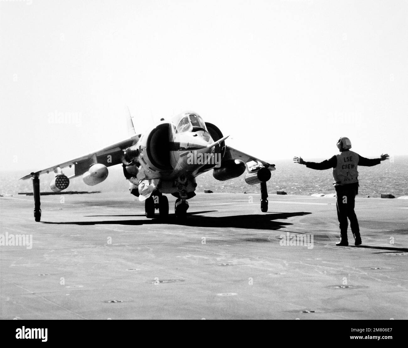 Un équipage de plate-forme de vol signale au pilote un avion de décollage et d'atterrissage (V/STOL) vertical/court de l'Harrier Marine AV-8C. Le Harrier, fabriqué par McDonnell-Douglas, Inc., est en cours d'essai et d'évaluation. Pays : inconnu Banque D'Images