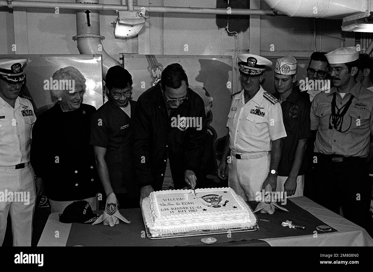 Le vice-président George Bush coupe un gâteau cuit en l'honneur de sa visite au porte-avions USS RANGER (CV-61). Lors de la cérémonie de coupure, il est accompagné, de gauche à droite, du Capt Tony Less, de Barbara Bush et DE VADM Crawford Easterling. Pays : Océan Pacifique (POC) Banque D'Images