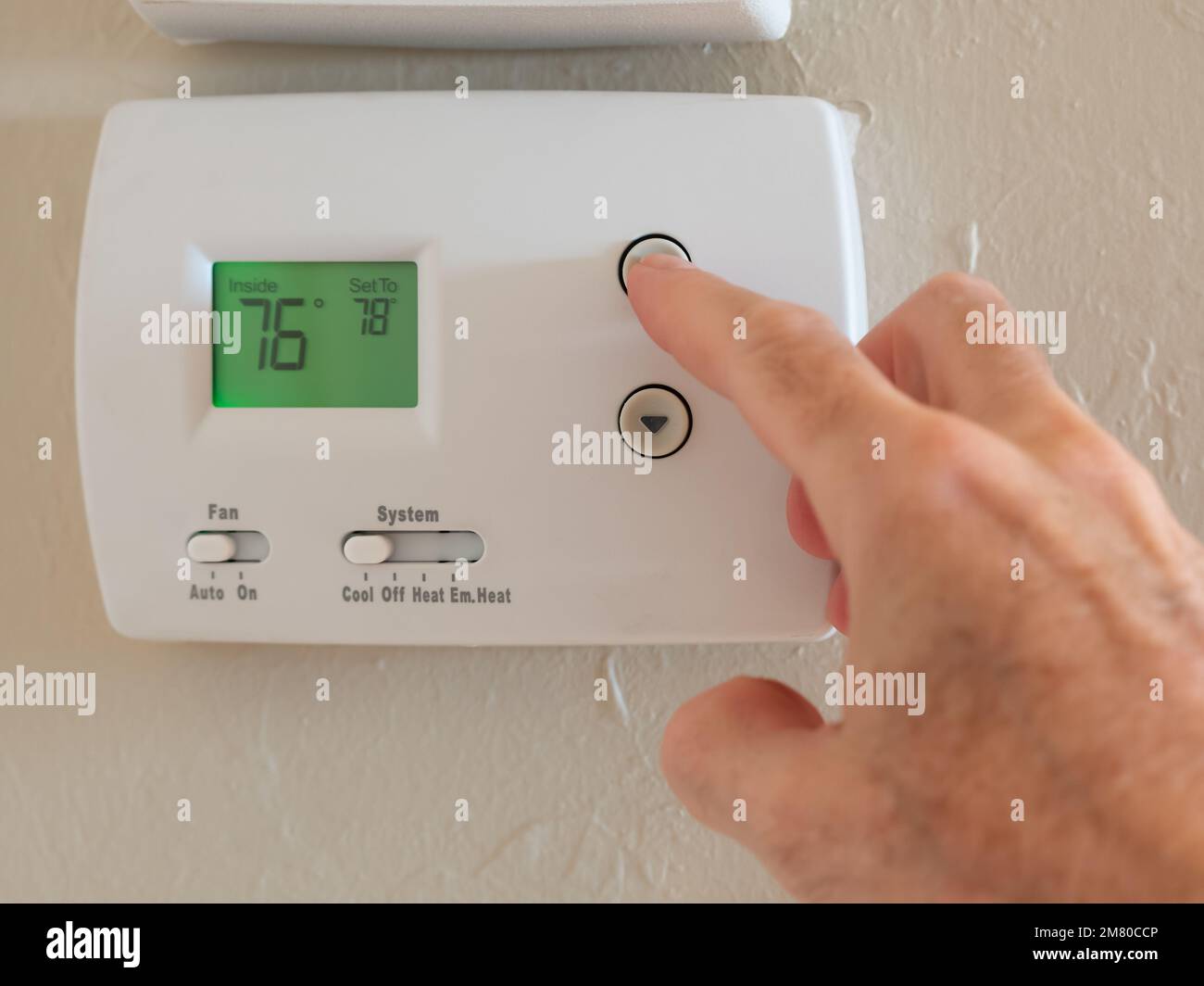Réglage du thermostat numérique sur froid et programmation de la climatisation à une température d'économie d'énergie de 78 degrés. Banque D'Images
