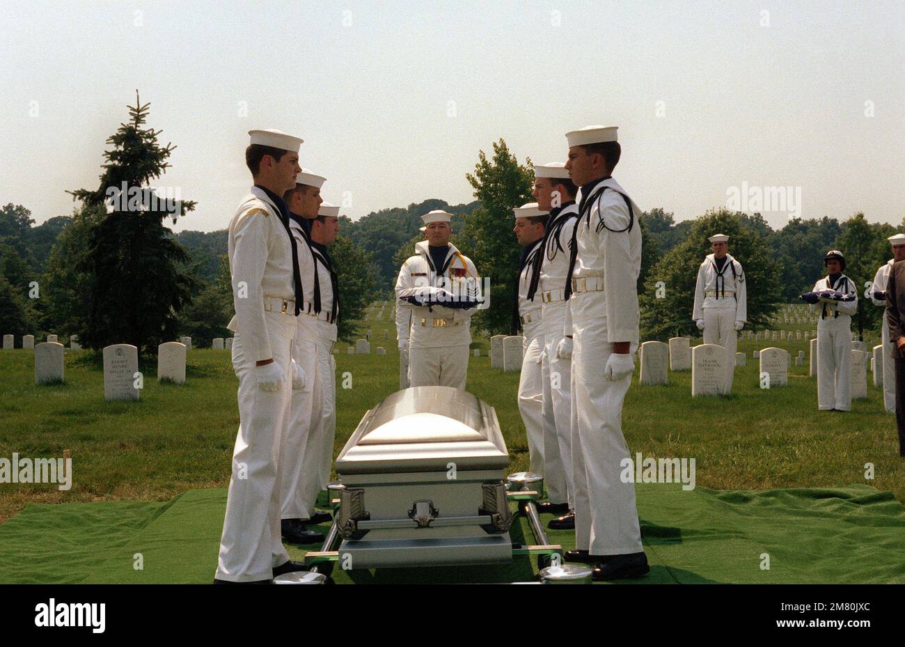 Membres des États-Unis La Garde de cérémonie de la Marine est à l'attention de la classe Mate 3rd de Boatswain Daniel Good détient le drapeau replié pendant les funérailles au cimetière national d'Arlington pour LE CAPC James T. Ruffin. Ruffin a été inscrit comme manquant-en-action après avoir omis de reprendre le vol d'une mission au large de la côte nord du Vietnam le 18 février 1966. Base: Arlington État: Virginia (va) pays: Etats-Unis d'Amérique (USA) Banque D'Images