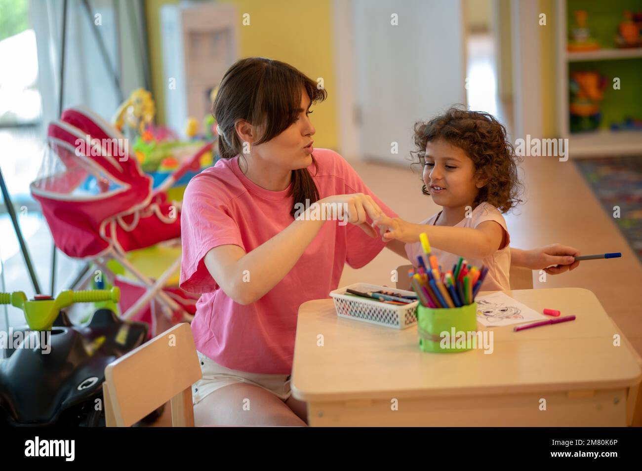 Maman et sa fille passent du temps dans un dessin de salle de jeu Banque D'Images