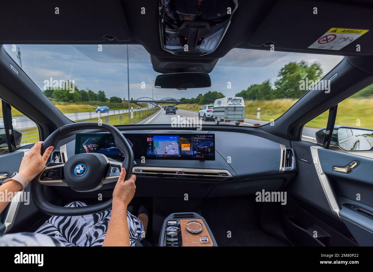 Belle vue intérieure de la voiture électrique BMW iX40 avec femme conducteur. Banque D'Images