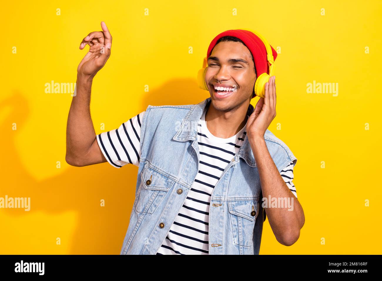 Photo de l'homme plein de joie et de funky porter des vêtements tendance chill Vibe profiter de belles chansons isolées sur fond jaune Banque D'Images