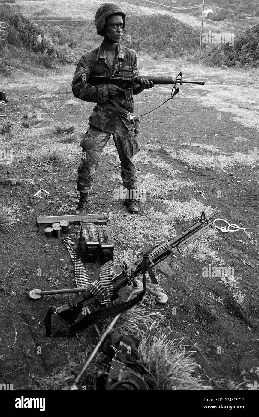 Un membre de la division aéroportée 82nd, armé d'un fusil M16A1, se tient près d'une mitrailleuse M60 montée sur trépied et d'une arme antichar légère M72 (LOI) pendant l'opération MULTINATIONALE multiservice URGENT FURY. Objet opération/série: FUREUR D'URGENCE pays: Grenade (GRD) Banque D'Images Un membre de la division aéroportée 82nd, armé d'un fusil M16A1, se tient près d'une mitrailleuse M60 montée sur trépied et d'une arme antichar légère M72 (LOI) pendant l'opération MULTINATIONALE multiservice URGENT FURY. Objet opération/série: FUREUR D'URGENCE pays: Grenade (GRD) Banque D'Images