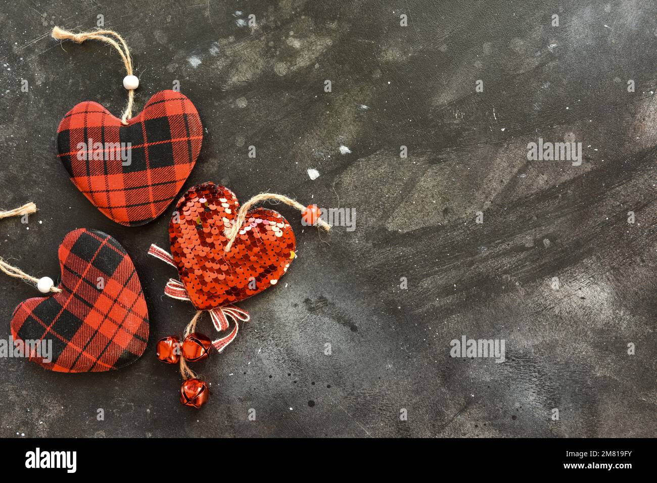 Vue de dessus de petits coeurs rouges sur un fond noir, Saint Valentin. Banque D'Images