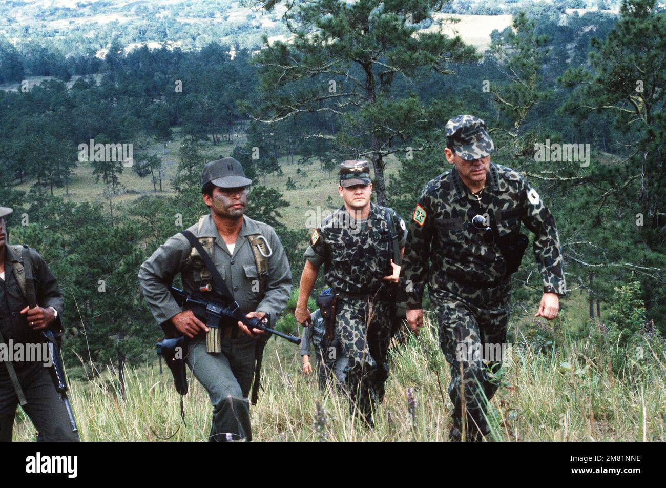 Le général Gustavo Adolfo Alvarez Martinez, chef des forces armées honduriennes, arrive dans la vallée de San Estaban avec ses aides et gardes du corps. Martinez est dans la région pour observer une chute de parachute par les troupes honduriennes pendant l'exercice AHUAS TARA (GRAND PIN) II Sujet opération/série: AHUAS TARA (GROS PIN) pays: Honduras (HND) Banque D'Images