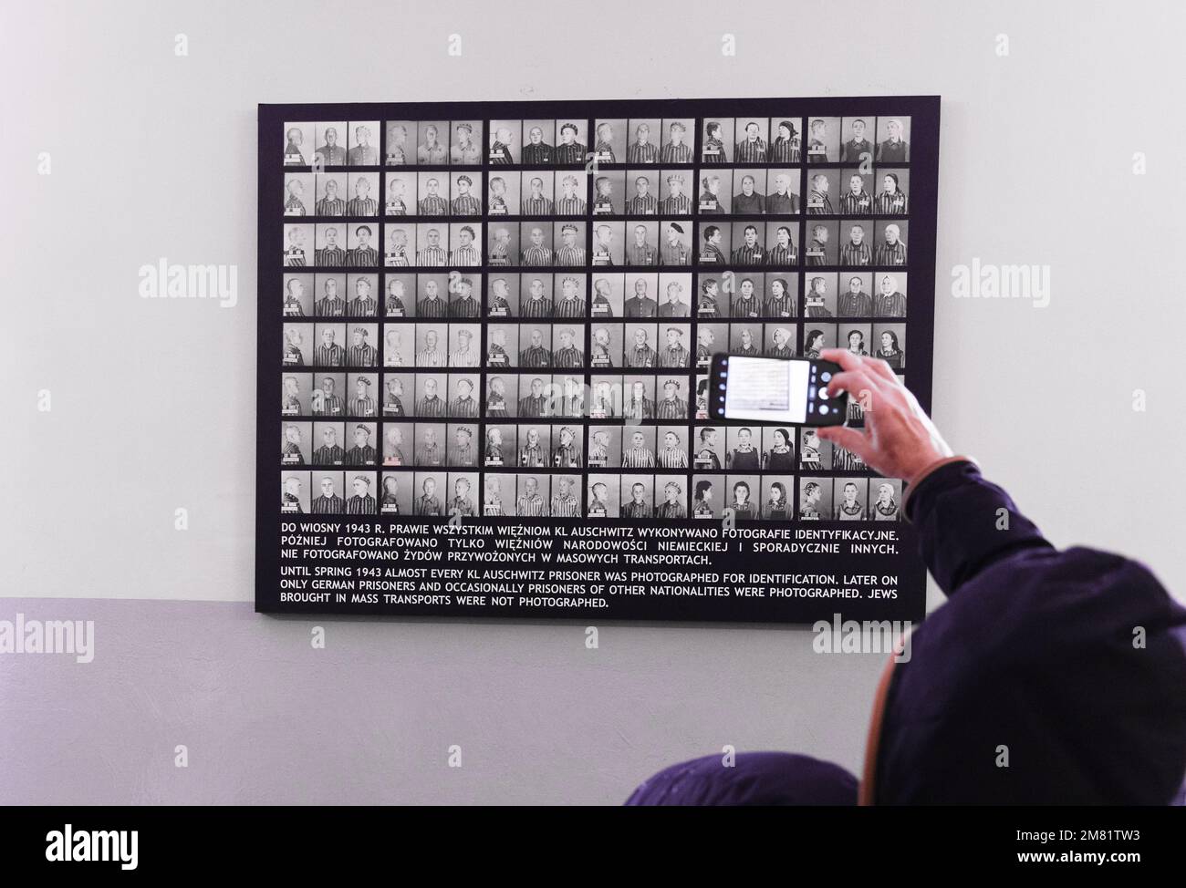 Intérieur du Musée Mémorial de l'Holocauste d'Auschwitz - visiteurs prenant une photo de vieilles photos de prisonniers, camp de concentration d'Auschwitz Birkenau, Pologne Banque D'Images