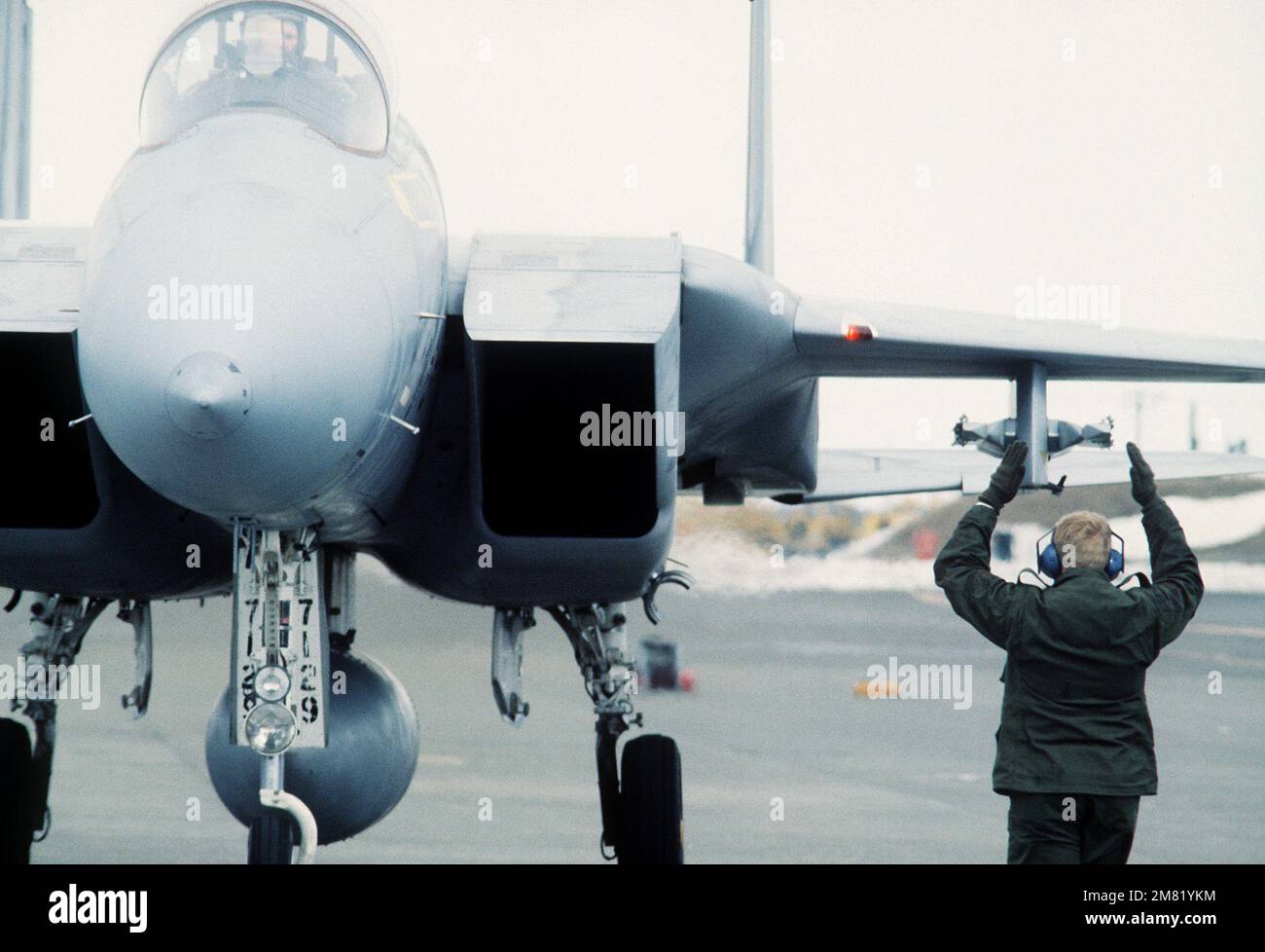 Un chef d'équipage dirige le pilote d'un avion F-15 Eagle sur le tablier pendant l'exercice Cope North 84-3. Objet opération/série : BASE COPE NORTH 84-3 : base aérienne de Chitose pays : Japon (JPN) Banque D'Images