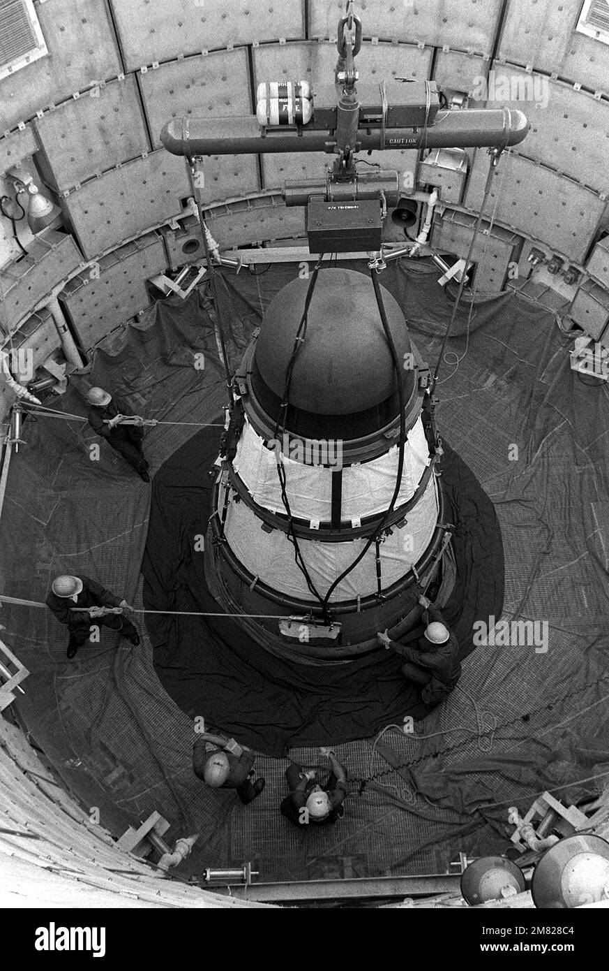 Les membres de l'escadron de maintenance des missiles 390th utilisent des cordes pour guider un véhicule de réentrée Titan II lorsqu'il est soulevé de son silo au site no 570-5. Base: Davis-Monthan Air Force base État: Arizona (AZ) pays: Etats-Unis d'Amérique (USA) Banque D'Images