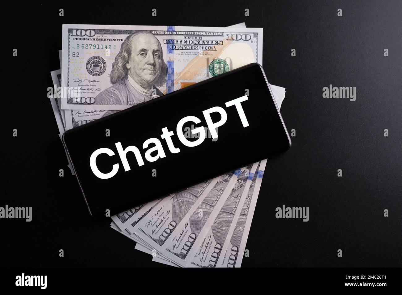 Logo ChatGPT vu sur le smartphone placé sur des dollars américains. Concept pour gagner de l'argent avec Chat GPT. Stafford, Royaume-Uni, 11 janvier 2023 Banque D'Images